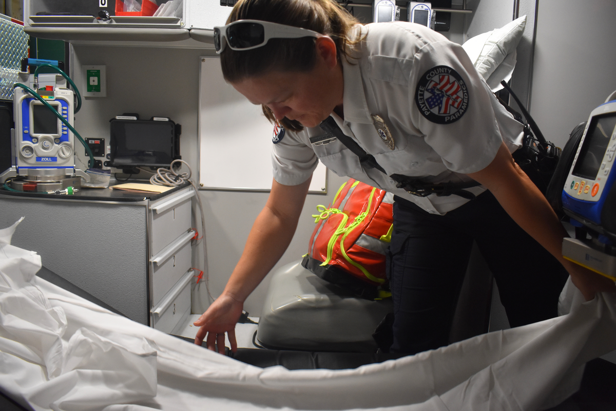 Christy McMillan, a Payette County paramedic, places a fresh sheet on the ambulance gurney during her morning shift. The paramedics always start their shift with counting and restocking supplies on the ambulance.