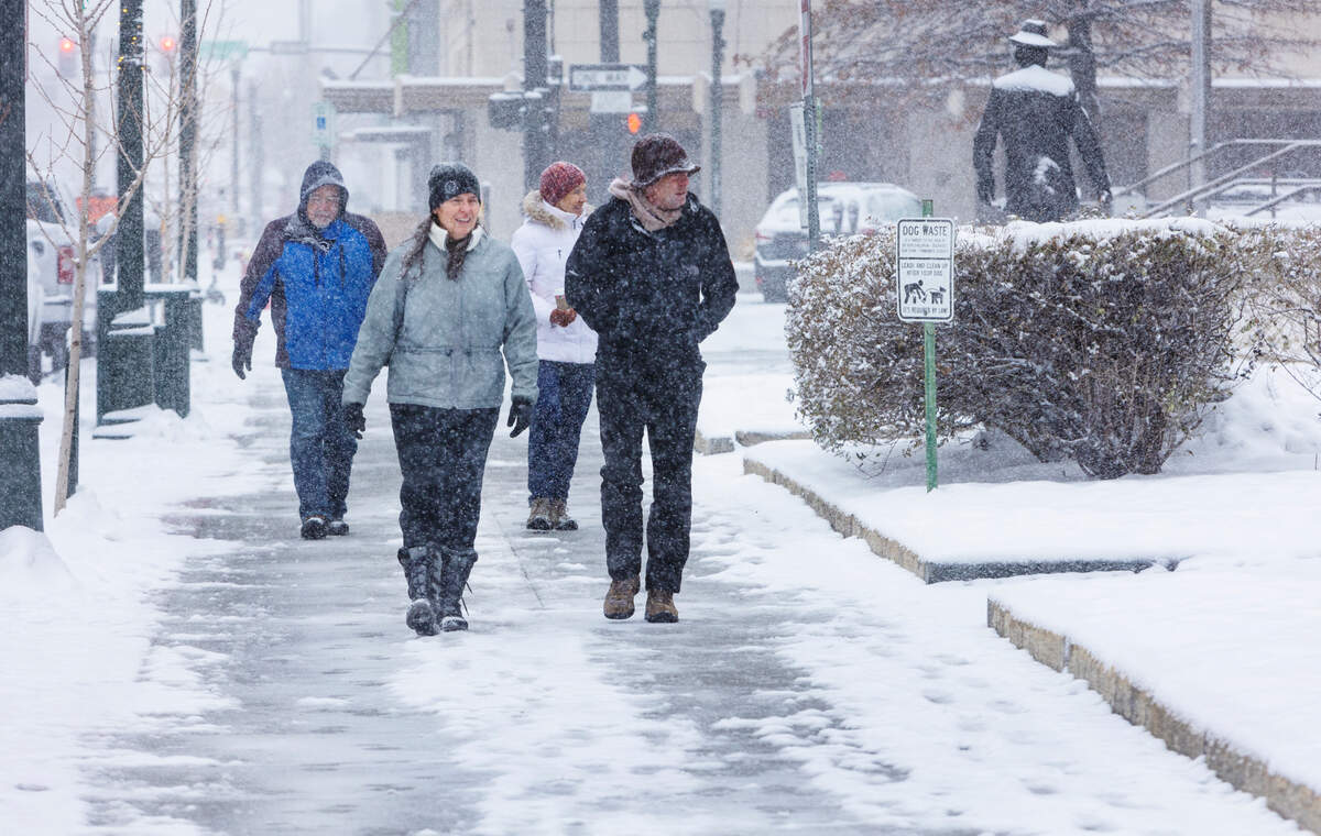 Kelly Hall and her brother Geof Finley take a walk in the snow along W. Bannock St. in downtown Boise on Wednesday, Dec. 29, 2021.