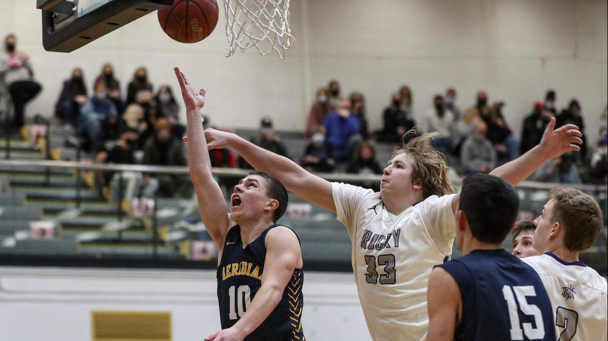 Meridian’s Drayson Fisher, left, hits a late lay-up during the 5A District Three championship game last week against Rocky Mountain. He and the rest of the Warriors enter as the 5A state tournament favorites.