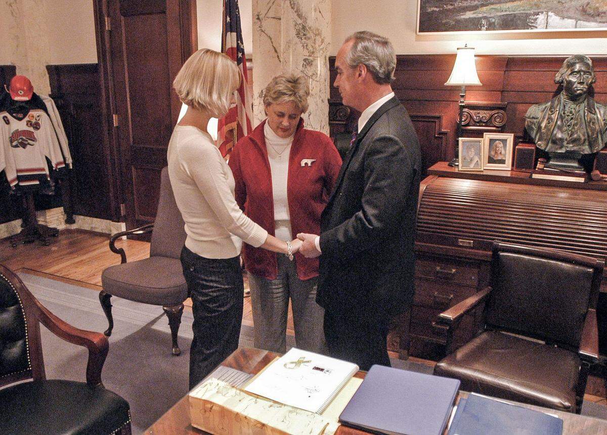 Idaho Gov. Dirk Kempthorne, right, prays with his wife Patricia, center, and daughter Heather, left, in his office before walking across the Statehouse to the House Chambers where he delivered his State of the State address to the 58th Idaho Legislature in January 2005. Kempthorne indicated in his speech that he would not seek a third term.