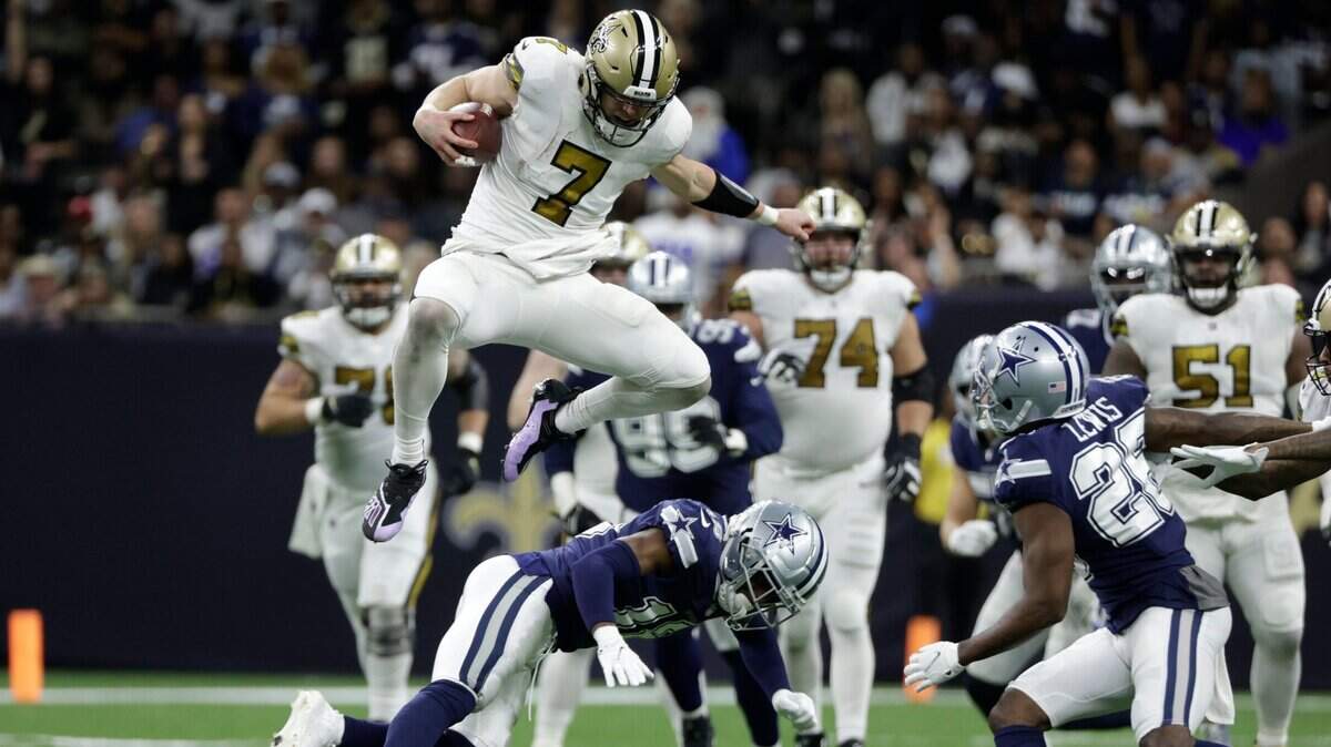 New Orleans Saints quarterback Taysom Hill leaps over Dallas Cowboys free safety Damontae Kazee during the second half of their game Dec. 2 in New Orleans.