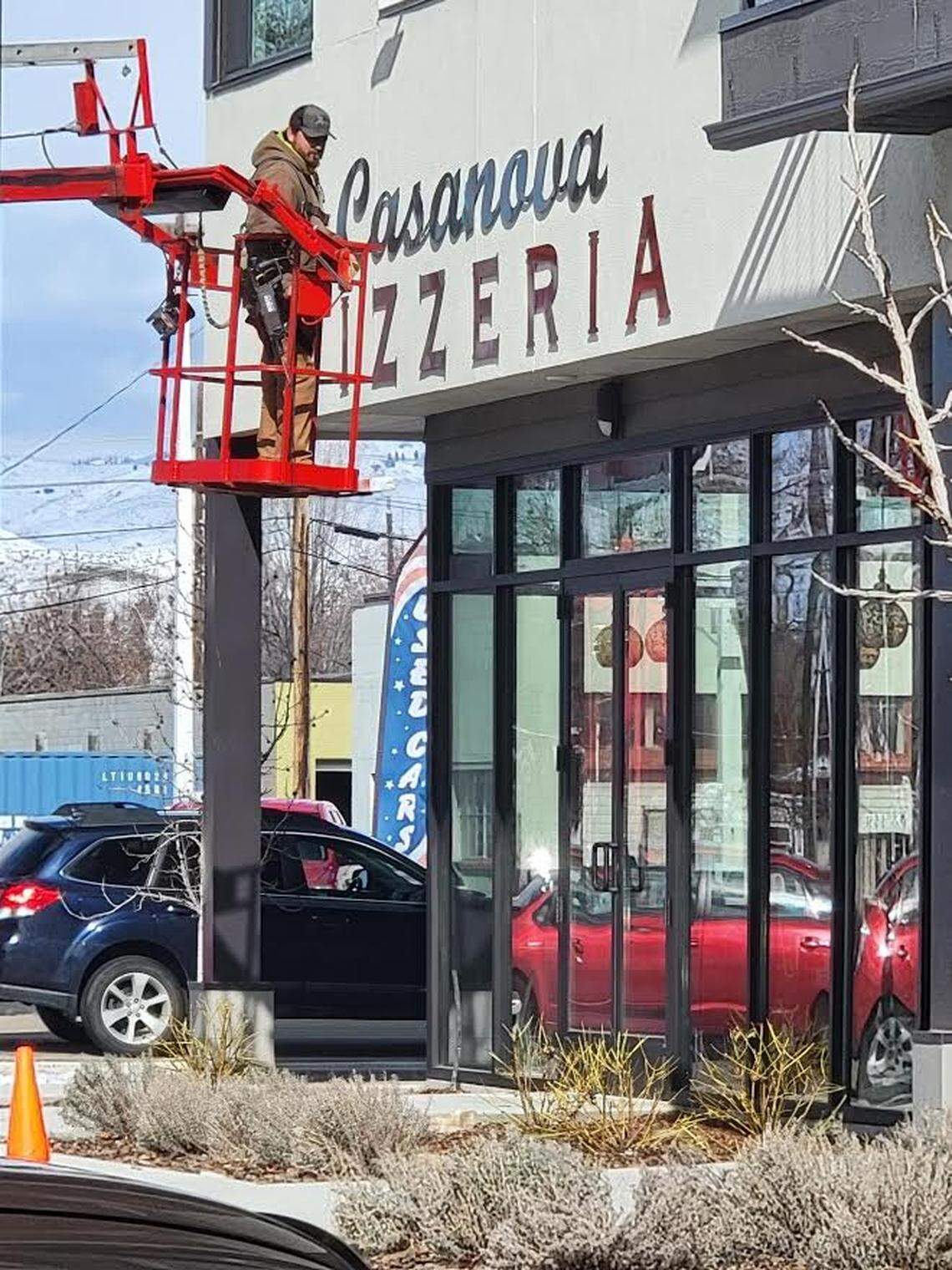 A worker installs the new sign at Casanova Pizzeria on 25th and Fairview in Boise.