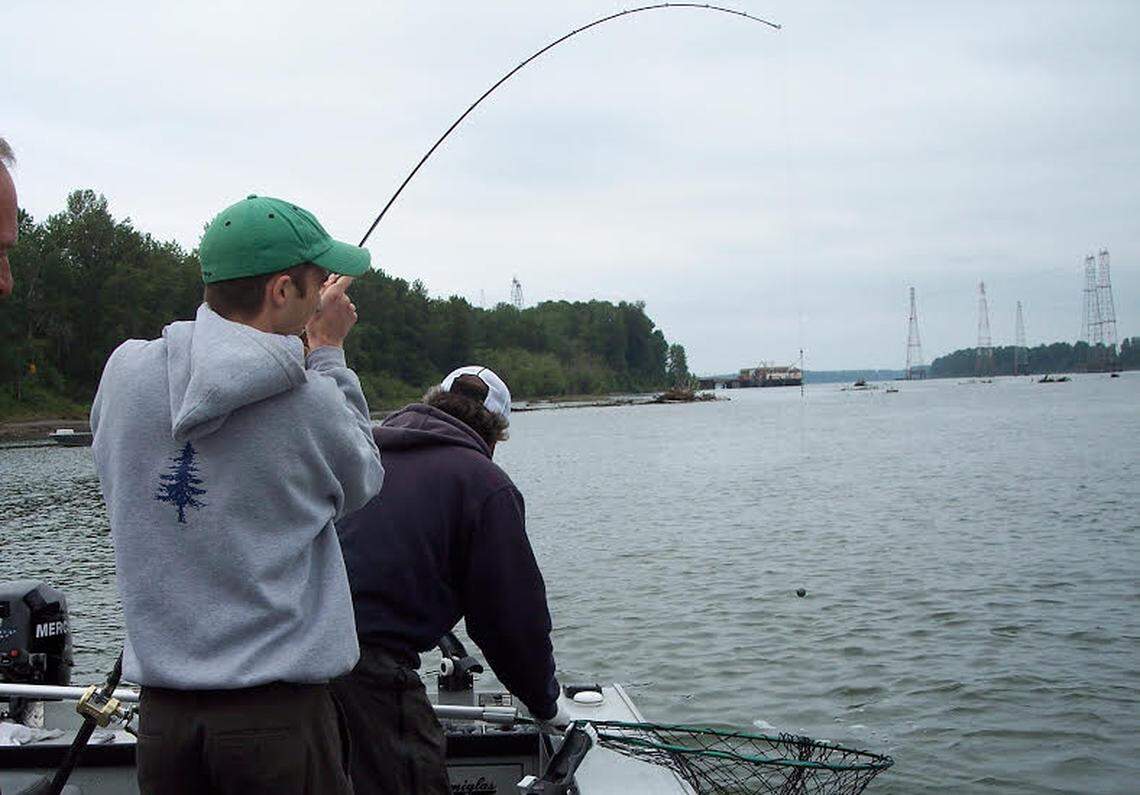 An angler fights a spring chinook near the mouth of the Sandy River with the Col;umibia in sight.