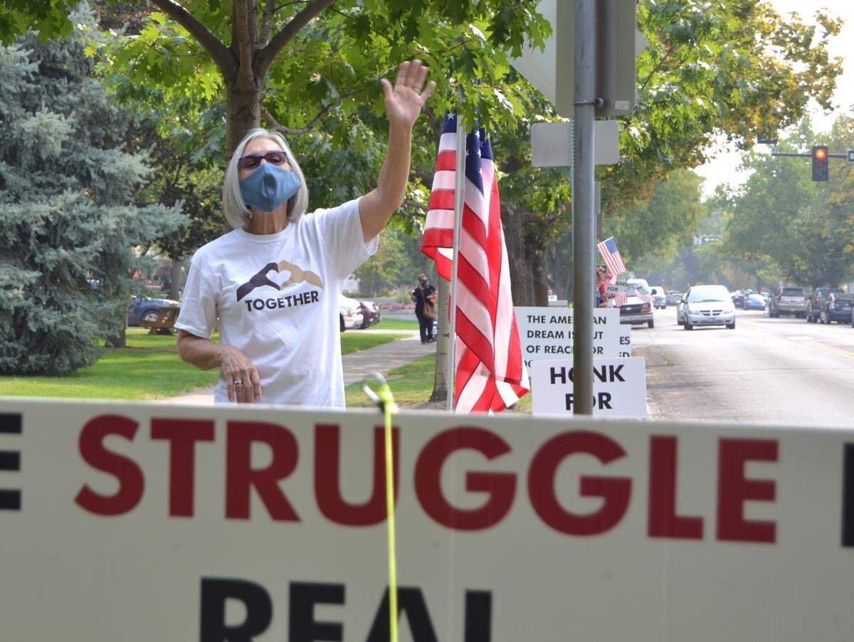 Mary Getchell waves to passing cars Monday during the daily “State Street Demonstration for American Values,” on State Street between Sixth and Seventh streets behind the Idaho State Capitol. Getchell has been coming to the daily noon-hour demonstration since the second day it began back in June.