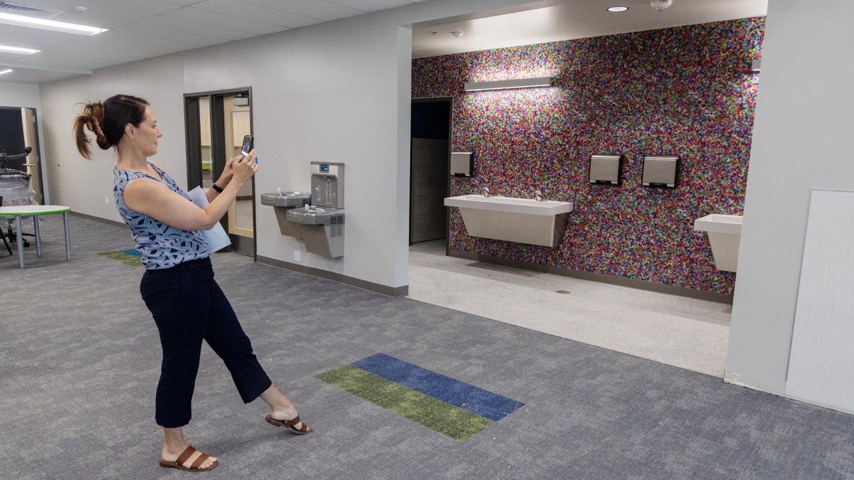 Boys & Girls Clubs of Ada County development director Jodi Gempler takes a photograph of the colorful backsplash behind the bathroom sinks in the game room of the club’s new facility in Kuna.