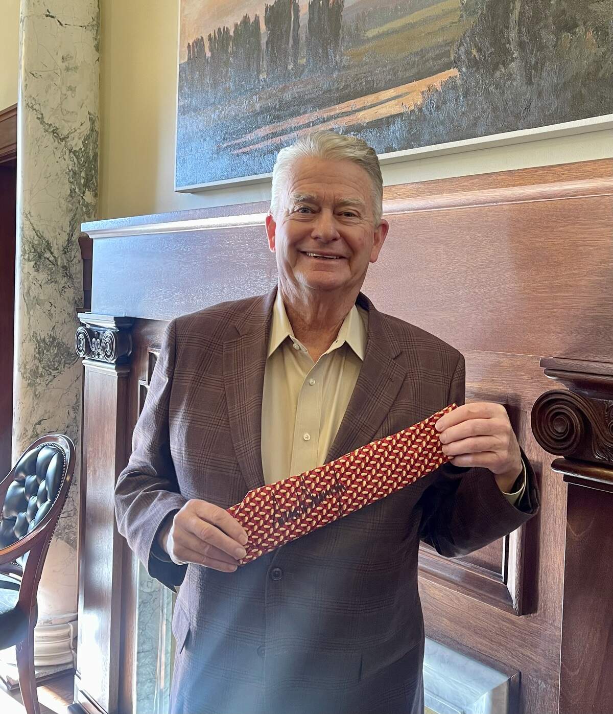 Idaho Gov. Brad Little exhibits an Idaho potato tie signed by President Donald Trump from a meeting with him last week at the White House in Washington, D.C.