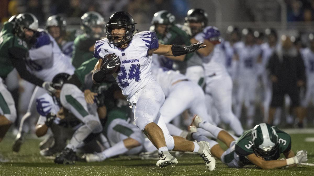 Rocky Mountain running back Nick Romano breaks through the line of scrimmage and runs for a 24-yard touchdown to ice the Grizzlies’ rivalry win over Eagle on Thursday at Thunder Stadium.