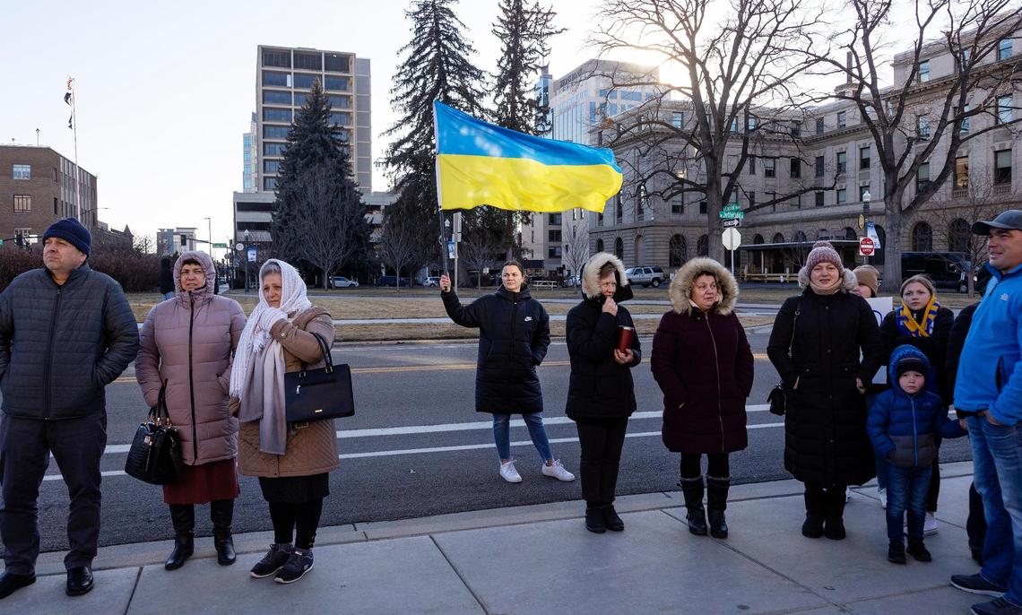 A woman holds the flag of Ukraine, center, as people gather outside of the Idaho Capitol Building on Saturday to rally against the Russian invasion of Ukraine.