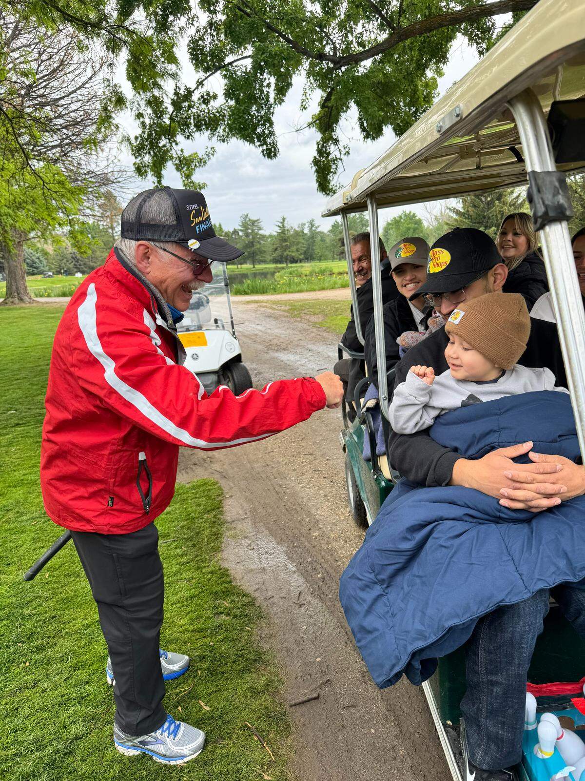Gus Gorringe, of Gorringe Brothers Construction, which has been a part of the Friendship Scramble for 33 years, fist-bumps last year’s recipient Jayden Chavez.