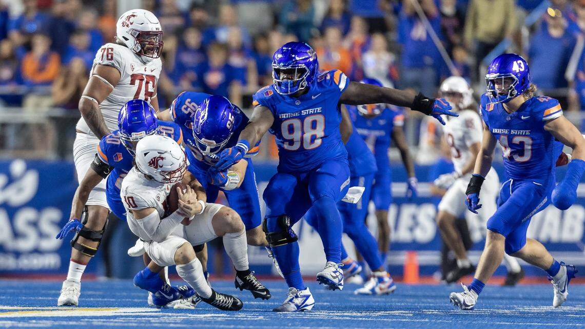 Boise State cornerback Davon Banks, left, and defensive end Max Stege sack Washington State quarterback John Mateer last season. 