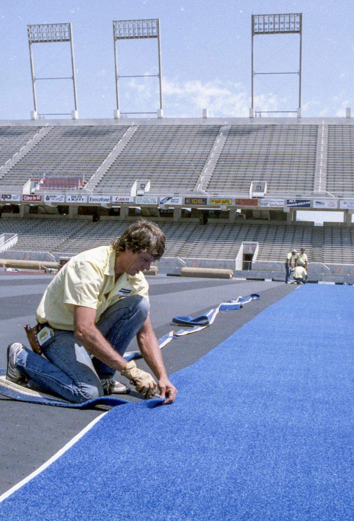 Crews install blue turf at Bronco Stadium in Boise, July, 18, 1986.