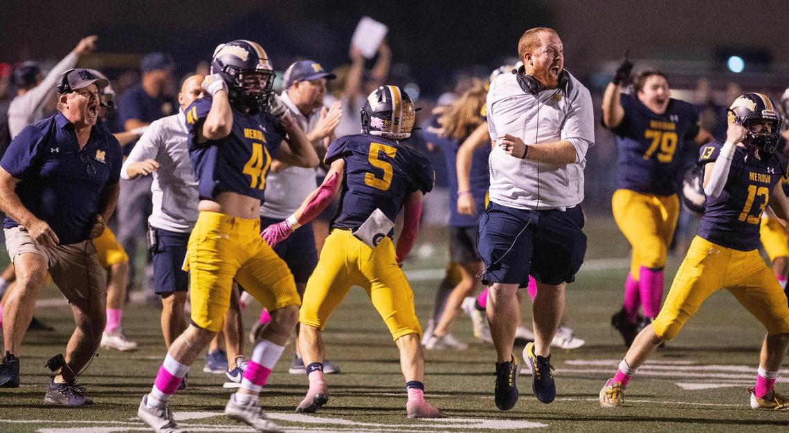 Players and coaches run onto the field to celebrate after Meridian stopped a 2-point conversion with 1 second left to hang on for a 14-12 win over Rocky Mountain on Friday.