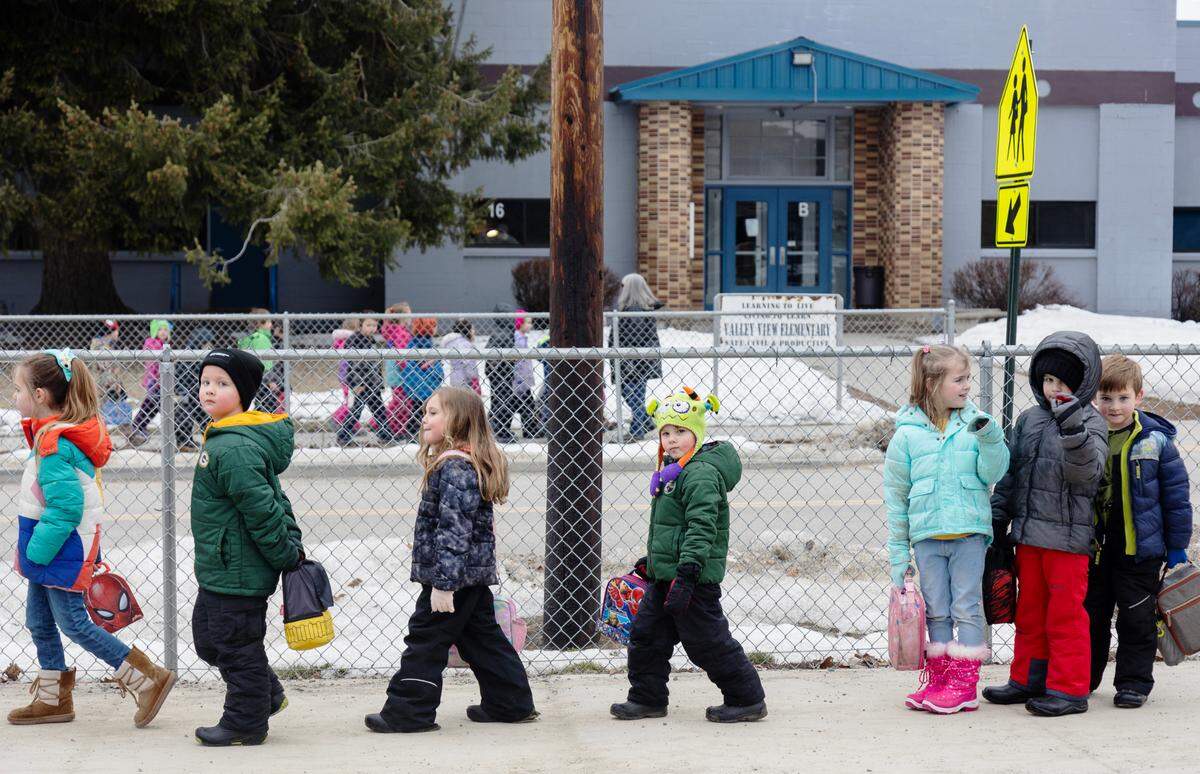 Kindergarteners cross the road between their classroom building and the main campus multiple times each day.