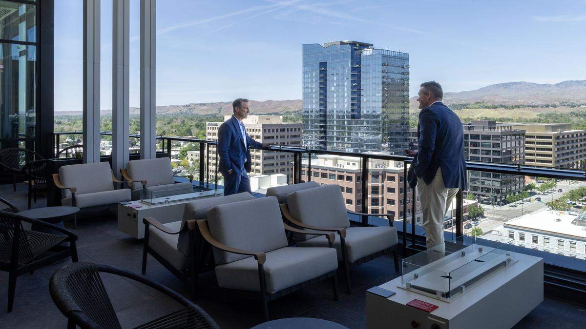 Jared Smith and Thomas Lewis, right, co-founders of Eagle-based Pennbridge Hospitality, enjoy the view from the patio lounge overlooking downtown Boise. 