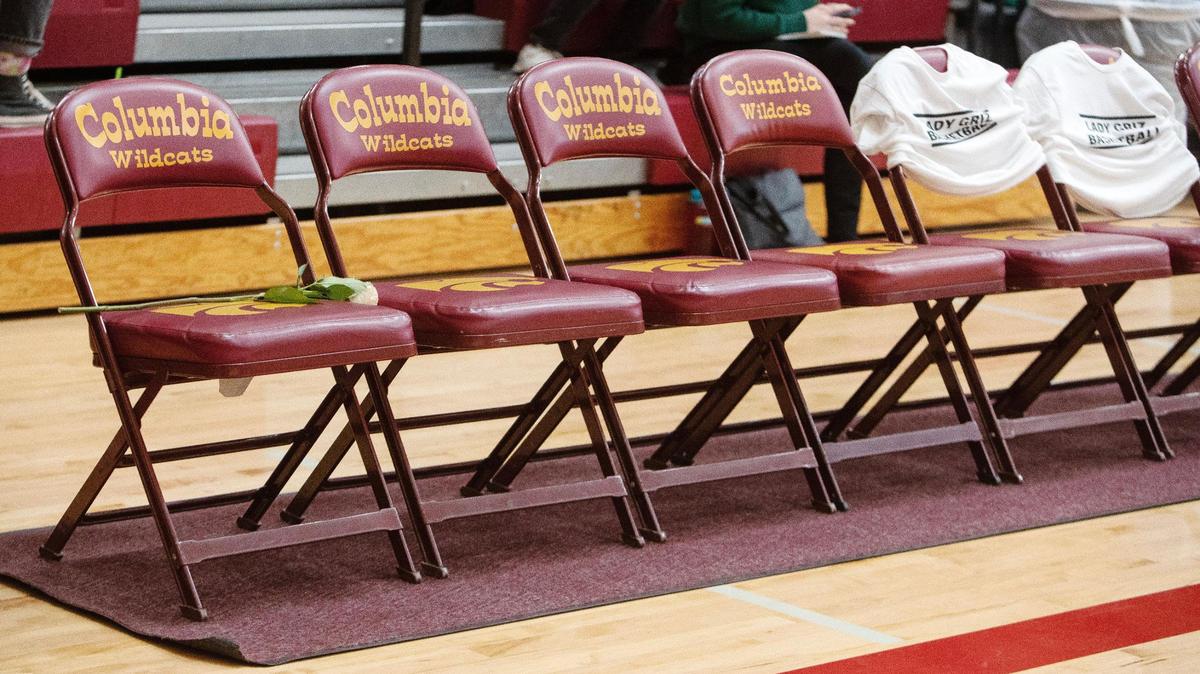 A light pink rose rests on the last chair of the Greenleaf Friends Academy girls basketball team bench in remembrance of coach Loma Bittick, who was killed in a car wreck just a week prior in February 2023.