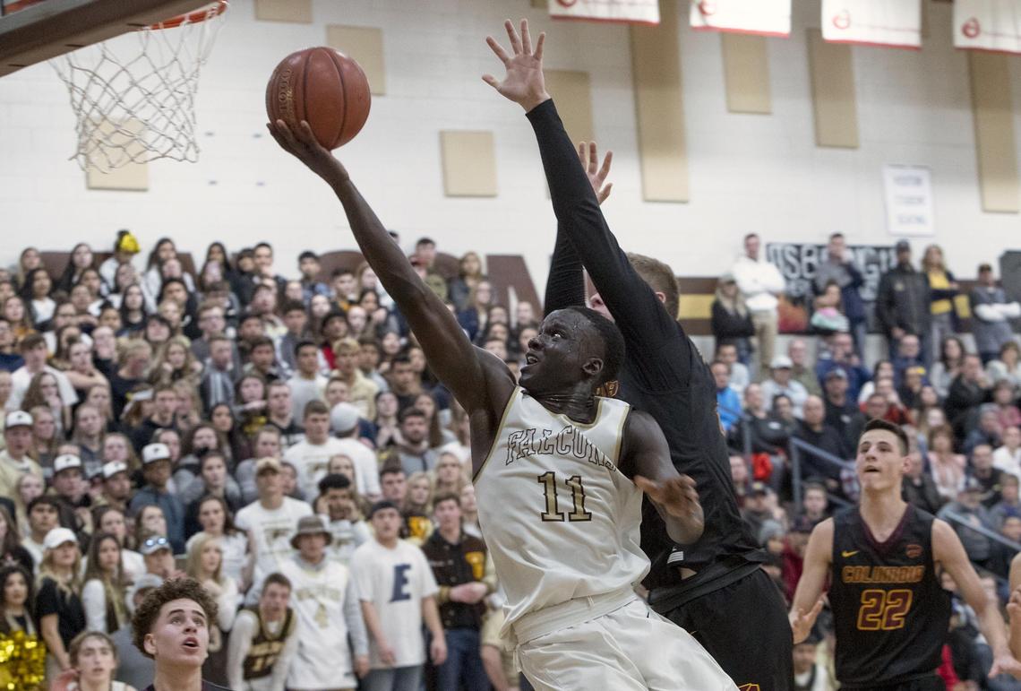 Vallivue senior Amoro Lado drives the lane under the reaching arm of Columbia’s Tripp Pugmire in the 4A District Three championship Feb. 21 at Vallivue High.