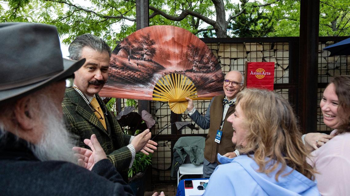 Appraiser Mark Mason Jr., center, holds a large fan that a guest brought to the “Antiques Roadshow” event at the Idaho Botanical Garden in Boise on Tuesday. The TV show will produce three episodes from the Boise event, and those episodes will run on PBS in 2023 for the show’s 27th season.