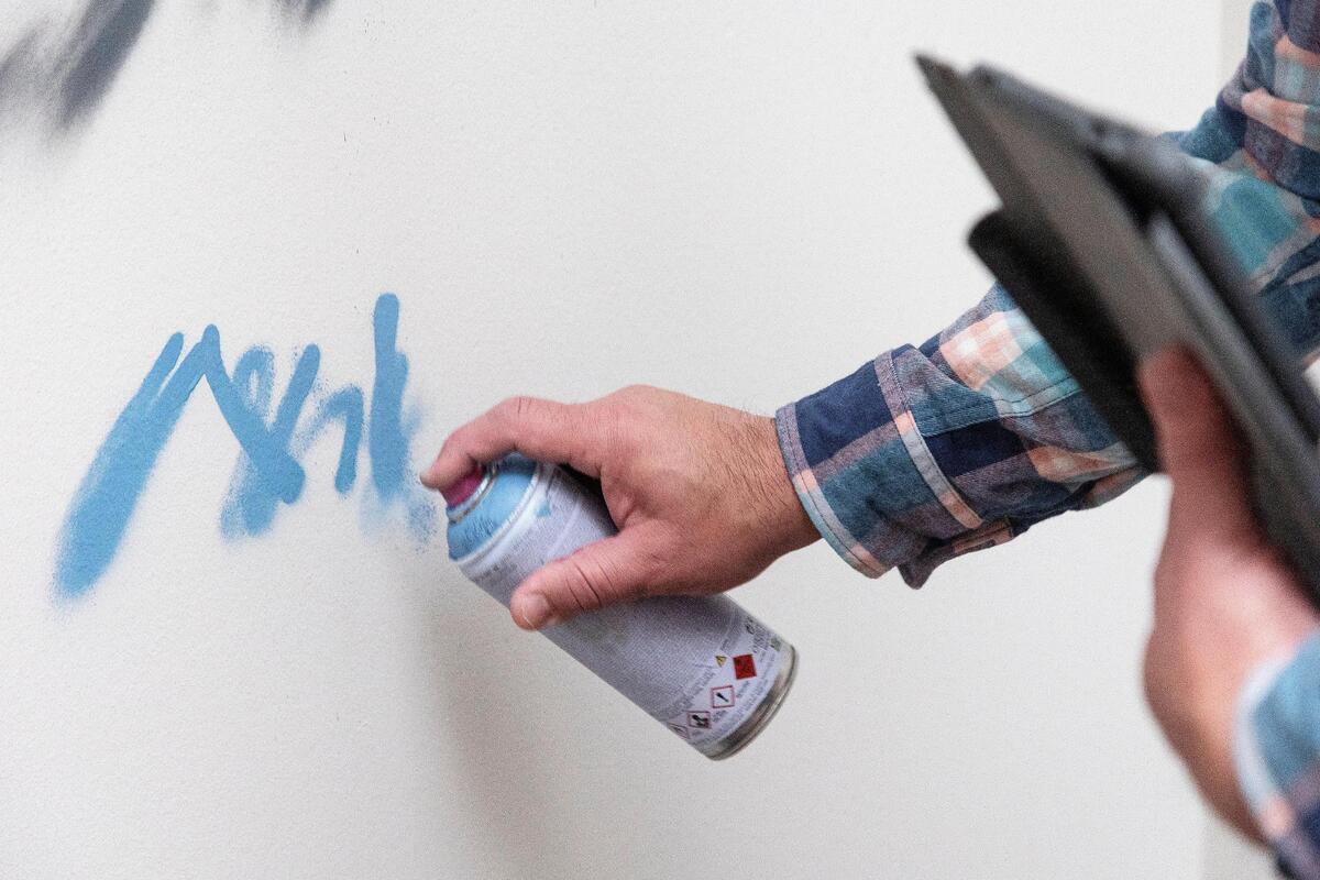 Bobby Gaytan, a Meridian resident, uses spray paint to sketch out a new mural at Whitney Elementary School in Boise. He grew up inspired by graffiti art in Texas.