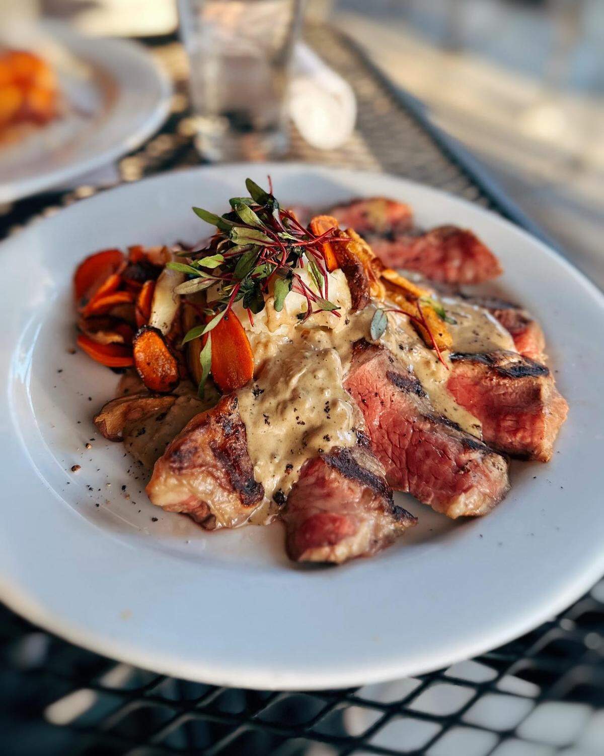 “Chef Danielle’s classic French Steak au Poivre features your choice of grass-fed steak pan-fried in its juices along with cognac, cream, and fresh cracked pepper,” the bistro wrote on social media. “Though the sauce is rather simple, we guarantee this pan sauce will turn any evening into your Parisian dinner dreams.”