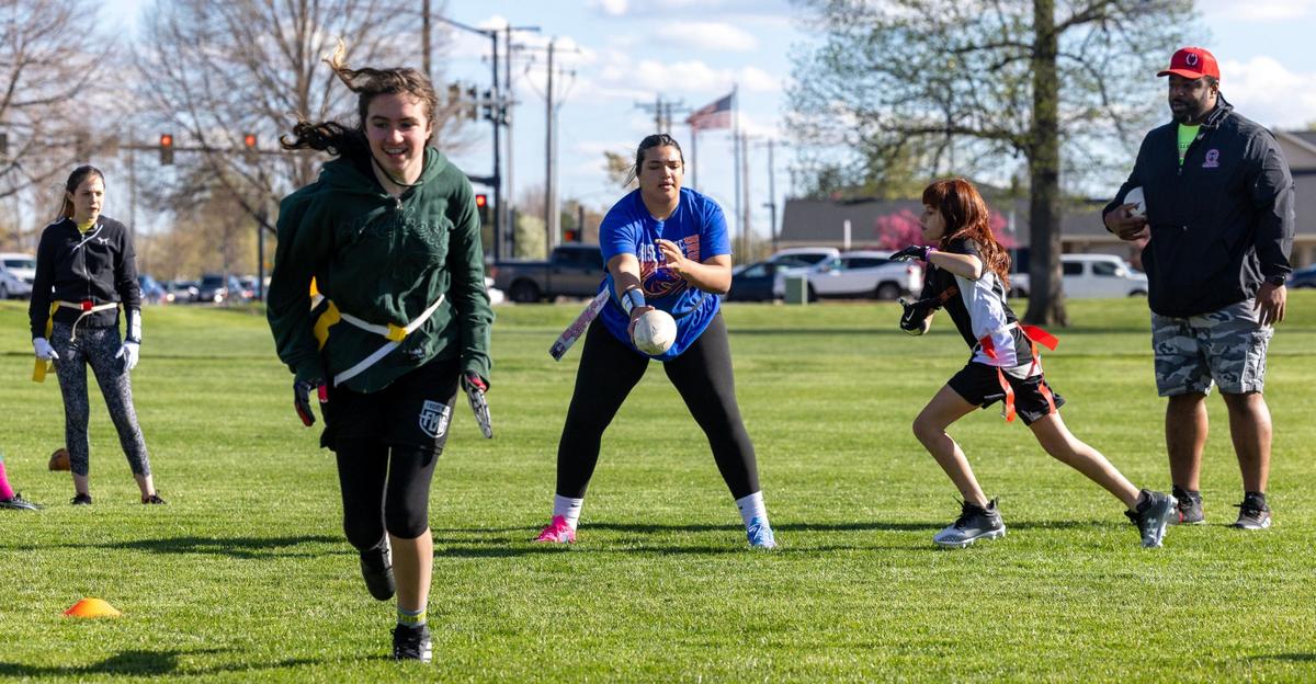 Optimist Youth Football Girls Flag 5’s player Neasjah Ellis, 12, center, hands the ball off to Kennedy Glenn, 11, in a play during practice April 17 at Settlers Park in Meridian.