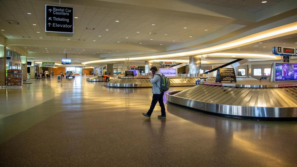A lone traveler from Los Angeles paces while he waits for a ride in the all-but-deserted airport in Boise.