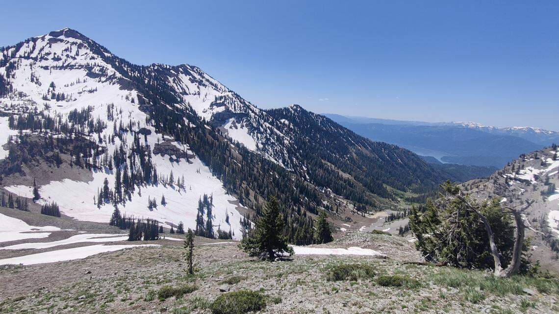The north face of Mount Baird, left, is shown rising above Palisades reservoir on June 7. The trailhead used to access the peak, as well as the peak itself, could be eligible for sale under the “One Big Beautiful Bill.”