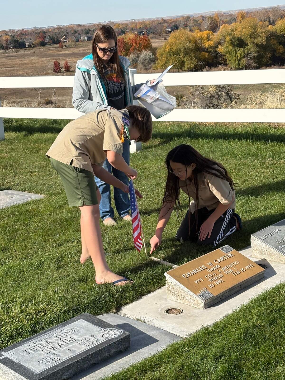 Cub Scouts from Pack 39 place flags by the graves of veterans at Joplin Cemetery on Saturday.