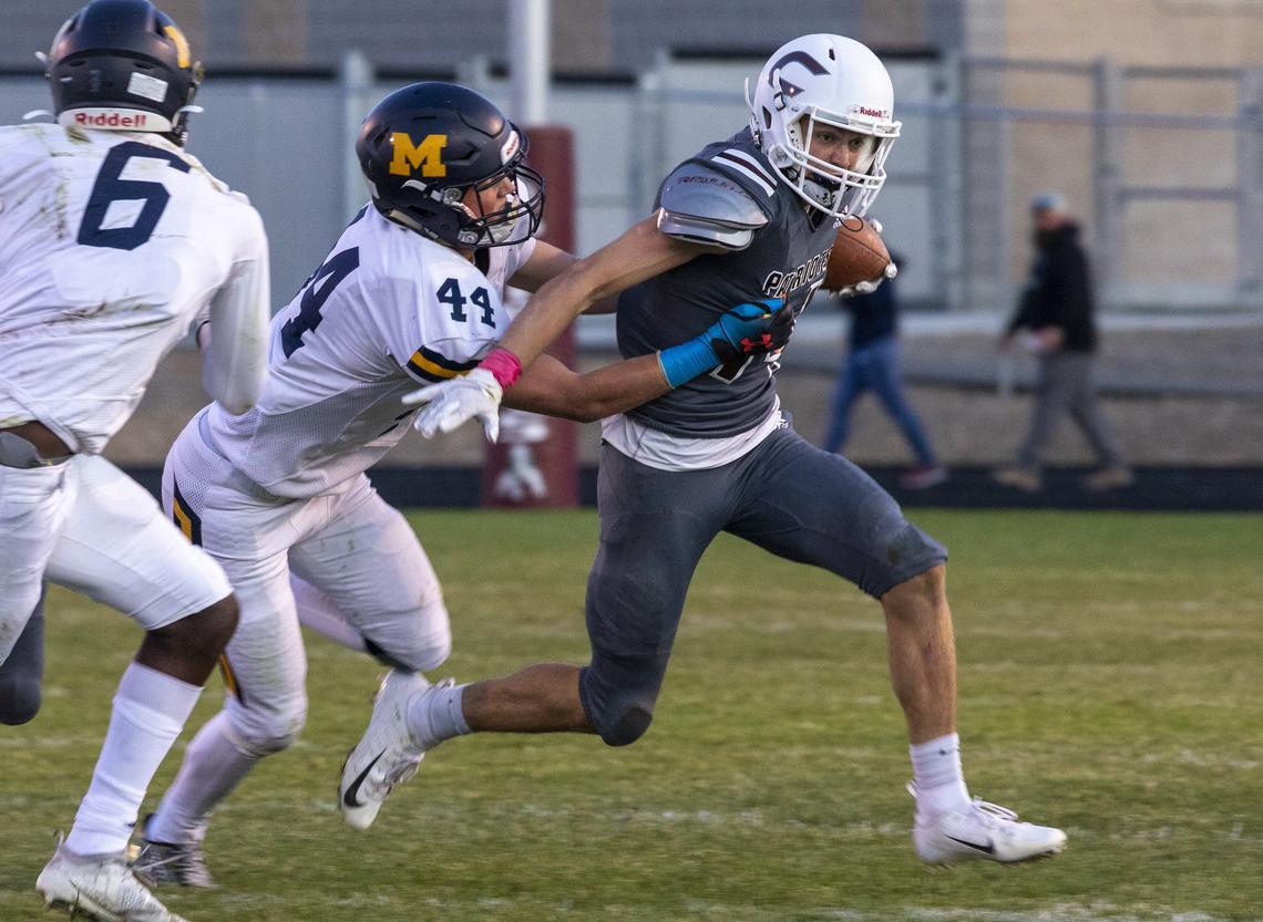 Centennial quarterback Luke Schabot shrugs off Meridian’s Emmitt Sallee on Friday night at Centennial High. The Warriors won 35-10.