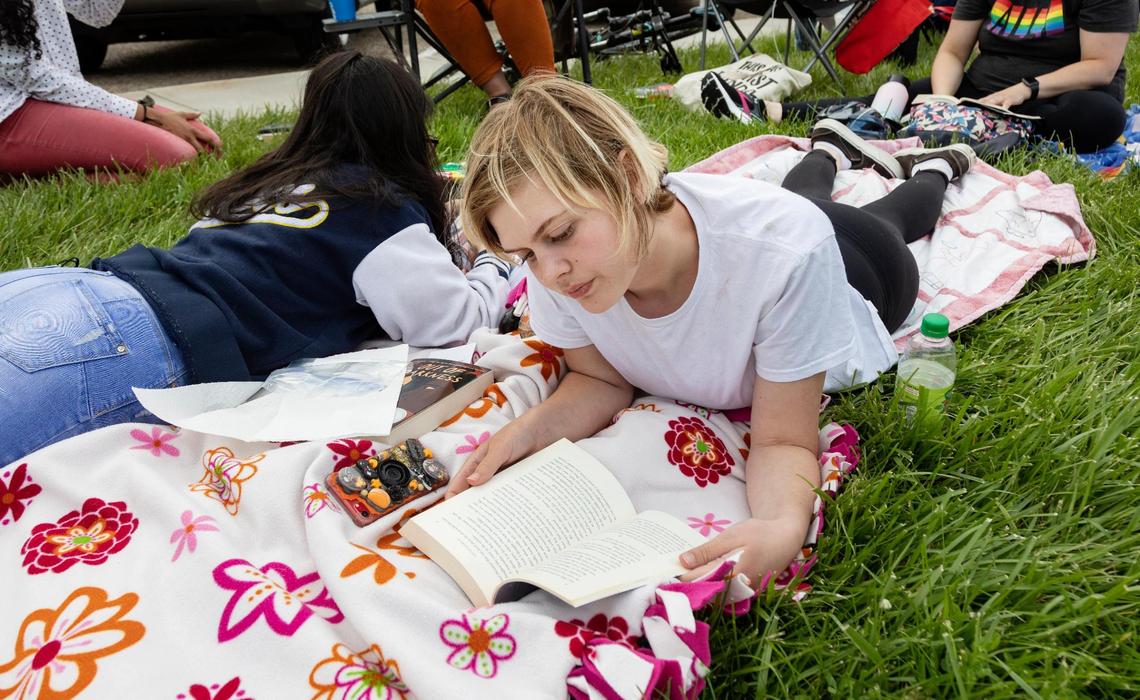 Nampa School District student Elizabeth Weitzel, 14, reads “13 Reasons Why” by Jay Asher at a demonstration outside of the school district office as the board meeting discussed the disposal of its banned books.