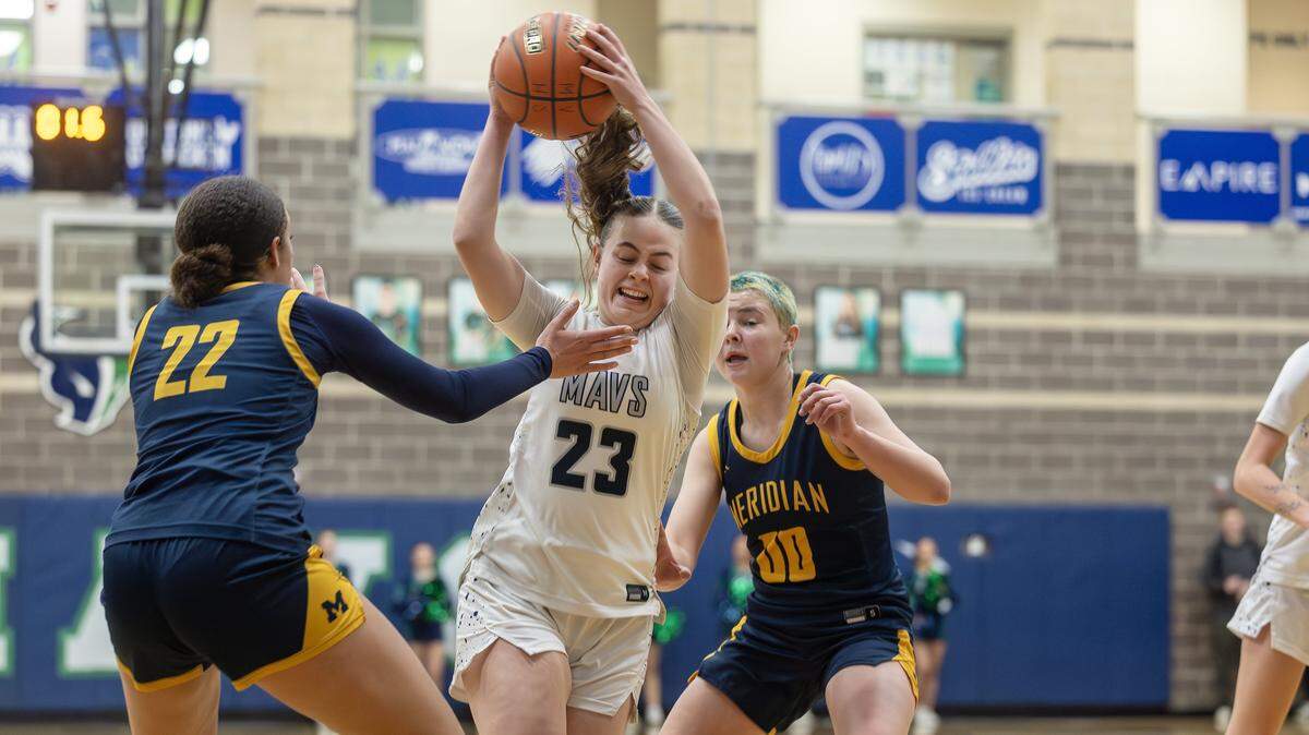 Mountain View sophomore Devry Huff controls the ball with Meridian sophomore Aniya Hancock-Lynch, left, and Chanel Schureman-Roe, right, defend during their 6A District Three girls basketball tournament play-in game, Tuesday, Feb. 3, 2026.