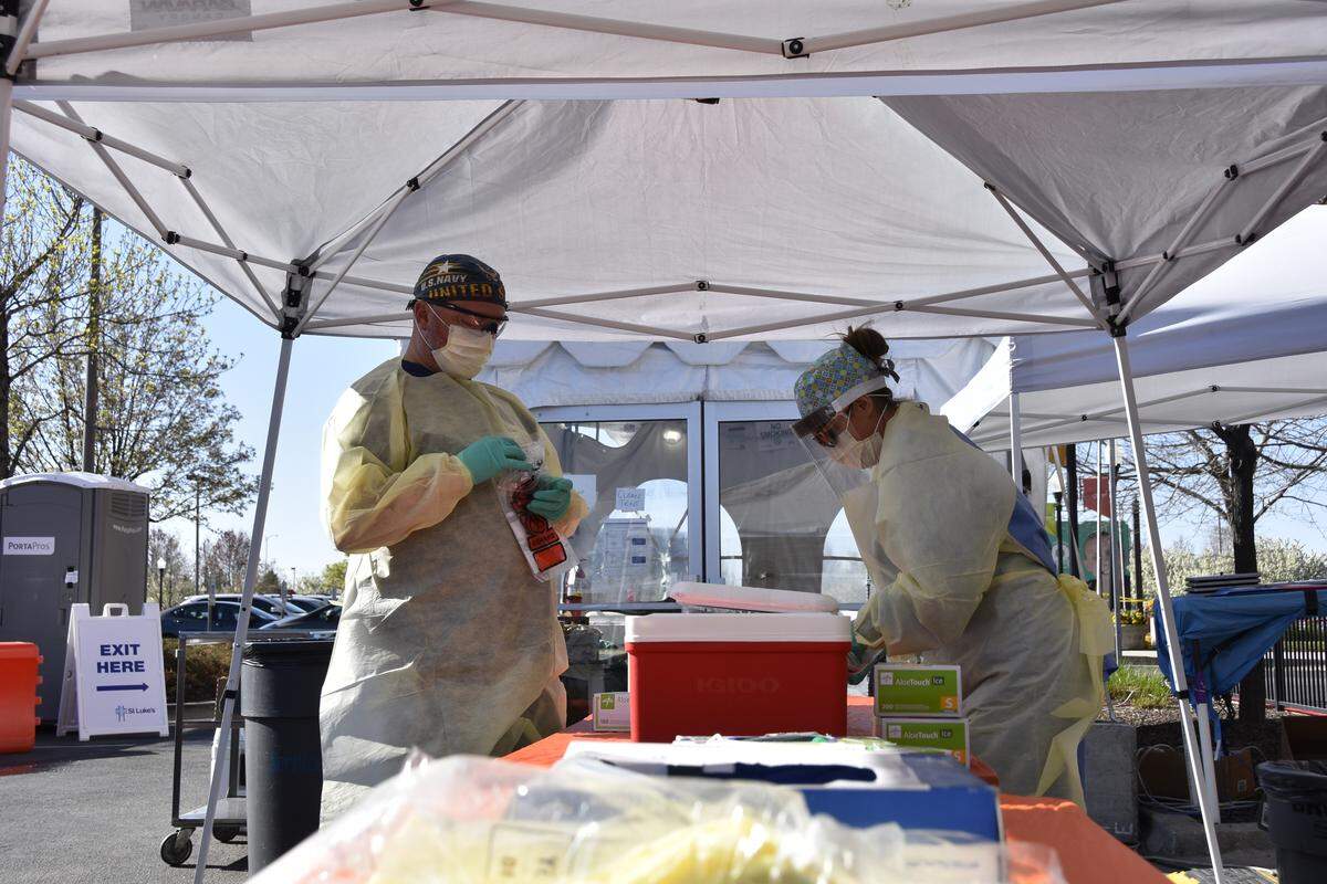Nurses Chris Colburn, left, and Ashley Layton put COVID-19 tests into a cooler while working the drive-thru testing line Friday morning at St. Luke’s Meridian Medical Center.