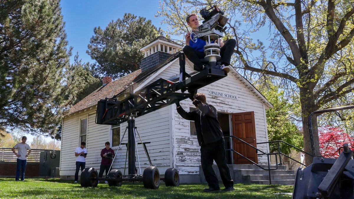 Boise State’s Zeke Hopkins operates a video camera while BSU Television Director Nathan Snyder pushes a crane boom for a sweeping panorama shot near the historic Opaline Schoolhouse located on the east side of campus.