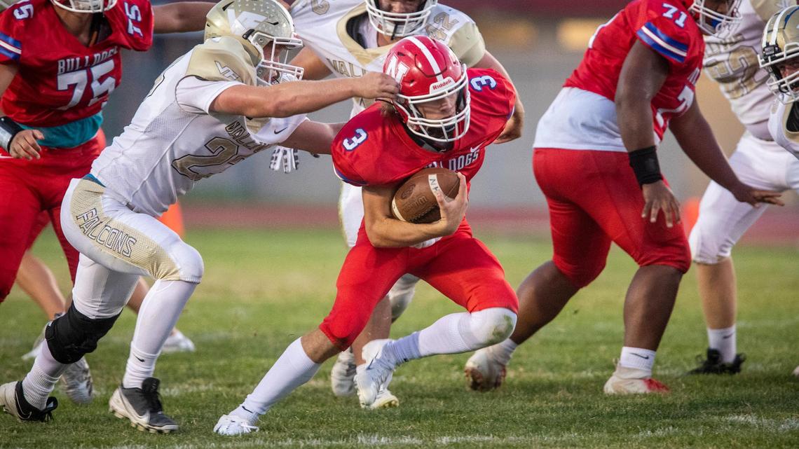 Nampa quarterback Isaak Plew eludes Vallivue’s Tanner Buckley. Nampa beat Vallivue 35-28.