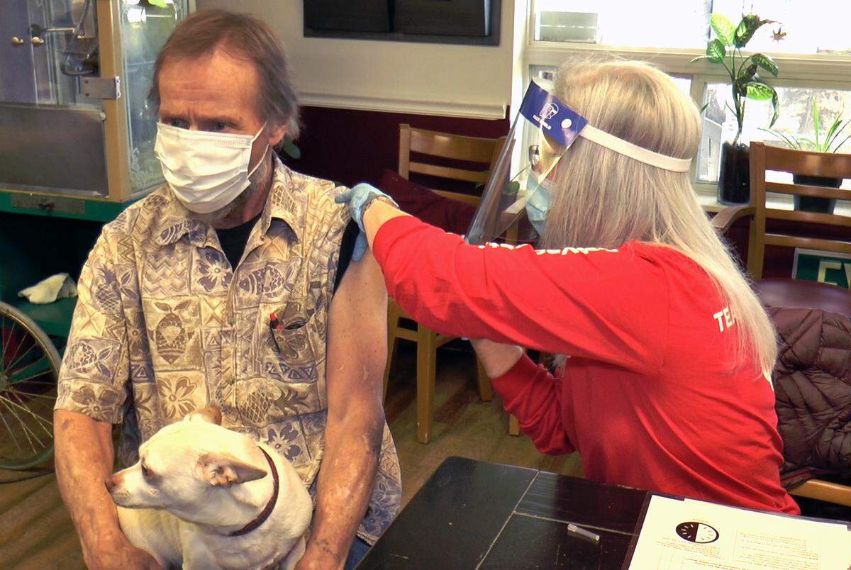 Catherine Martin, a faith community nurse volunteer with Saint Alphonsus, administers a COVID-19 vaccine to Good Samaritan Home resident Vince Werley, while his dog, Romeo, waits patiently on his lap. Some Saint Alphonsus patients were mistakenly billed for their shots.