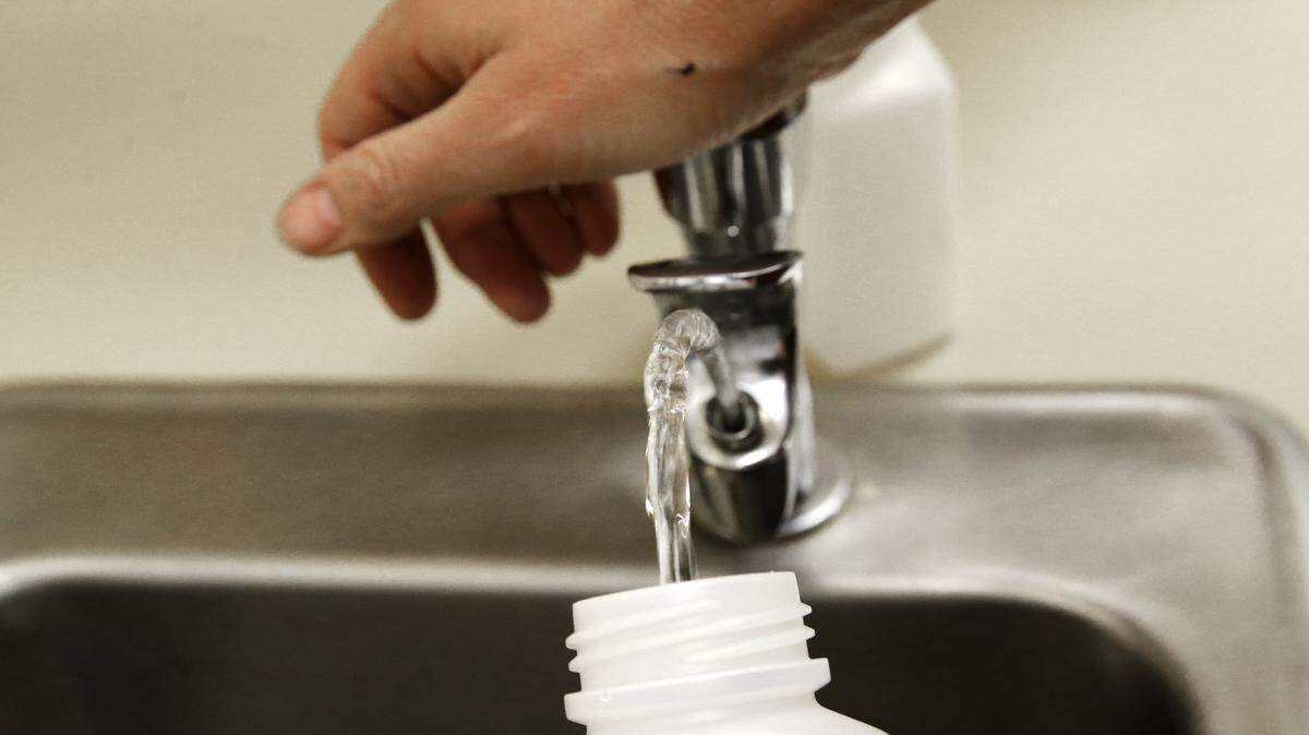 In this photo taken May 3, 2016, Donna McNeal, of Orion Environmental Services, collects a water sample from a classroom drinking fountain for lead testing at Fawcett Elementary School in Tacoma, Wash. The 27 schools in the Boise School District built before 1986 will be tested after Fairmont Junior High School tested positive for elevated levels of lead.