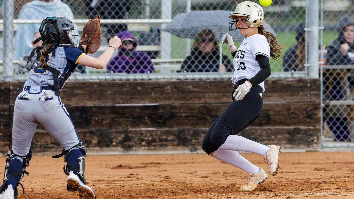 Capital junior Penny Lew-Barnett runs in to home plate before Meridian catcher freshman Jillian Dunkle can secure the catch in game one of the 5A District Three softball tournament held at Capital on Saturday.
