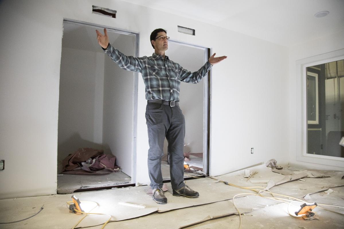 Scott Flynn, CEO of IndieDwell, gestures around the living room space of a container home. The company can now produce a 600- to 960-square foot container home in 28 days.