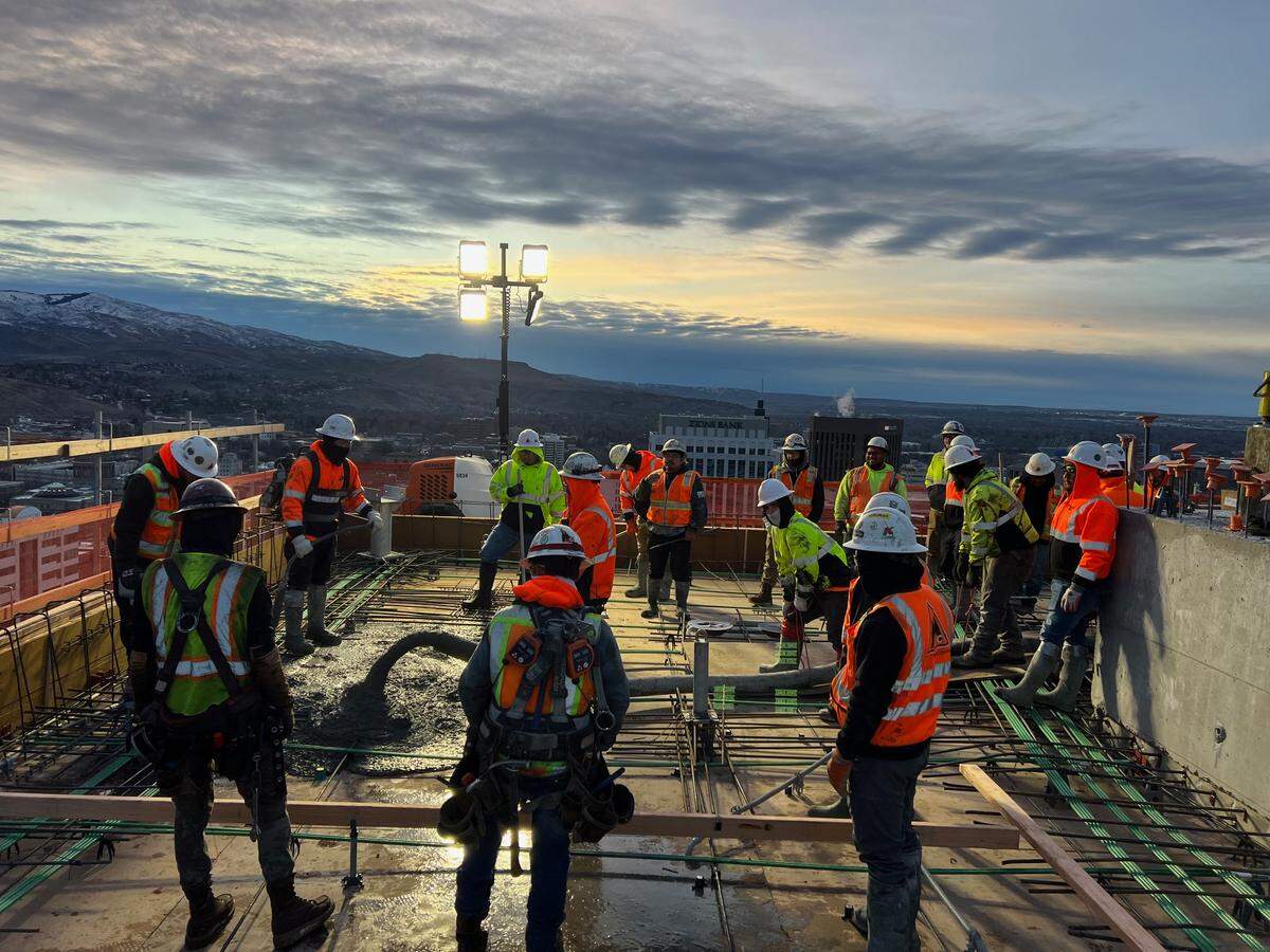 Workers pour cement during construction of The Arthur. The Zions Bank building can be seen in background, at center, and the U.S. Bank Building to its right.