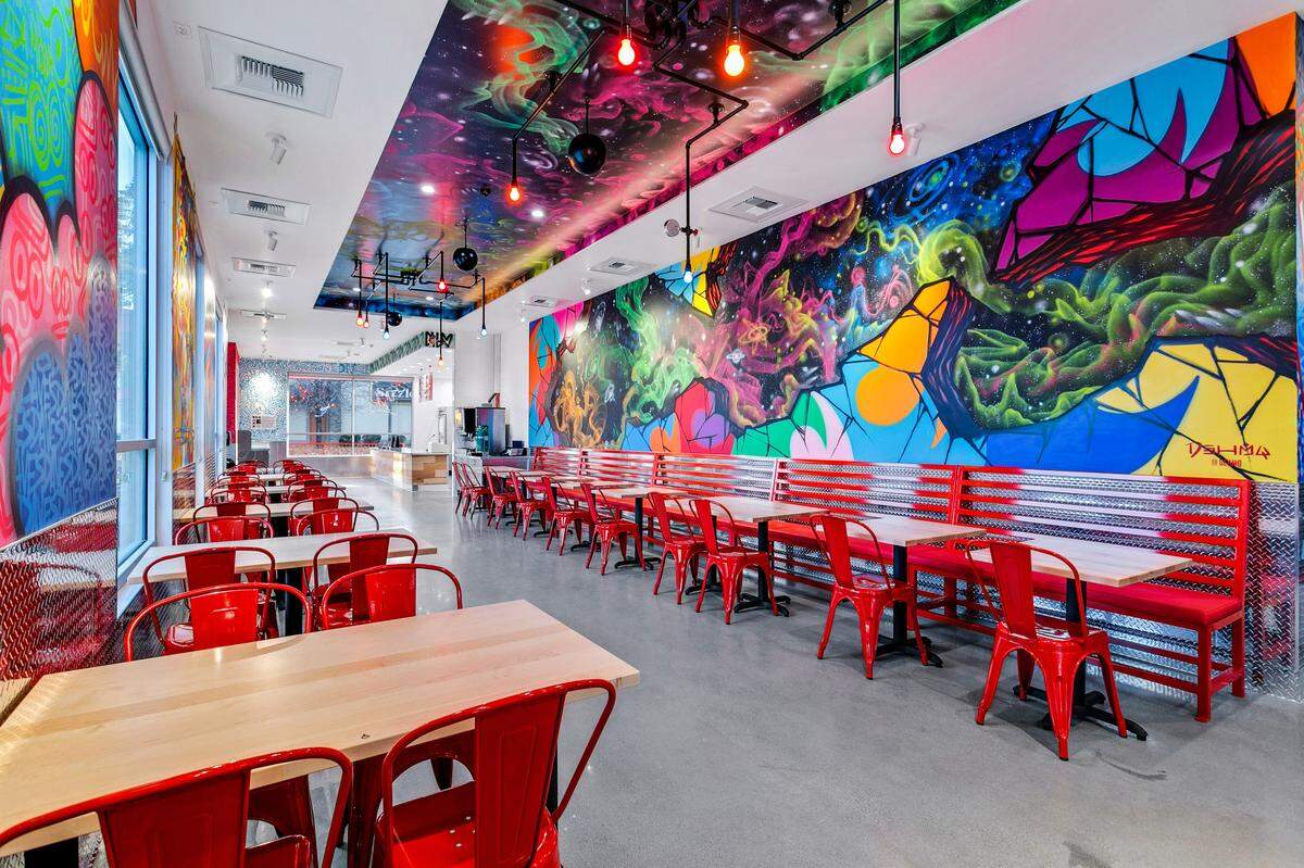 The interior features large, colorful artwork on the walls.