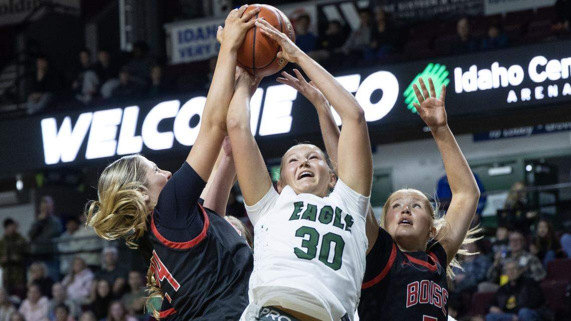 Eagle junior Berkley Jones battles for a rebound with Boise's Olivia Chatfield, left, and Eloise Chatfield in the 6A District Three girls basketball championship game at Idaho Central Arena in Boise, Friday, Feb. 13, 2026.