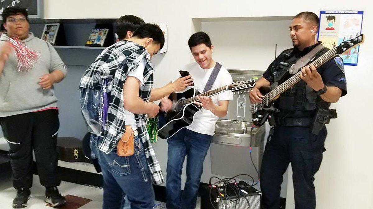 Martínez, a la izquierda, toca música española con el bajo con estudiantes de Canyon Springs High. Como ex alumno de una escuela alternativa, Martínez espera haber tenido un impacto en los estudiantes.