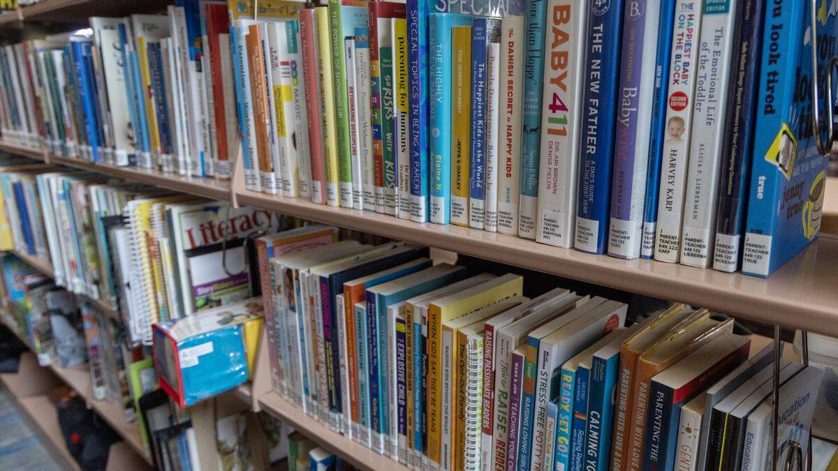 Books line the “Parent-Teacher” shelf. This shelf was moved out of the library’s children section, according to minutes from an August board meeting.