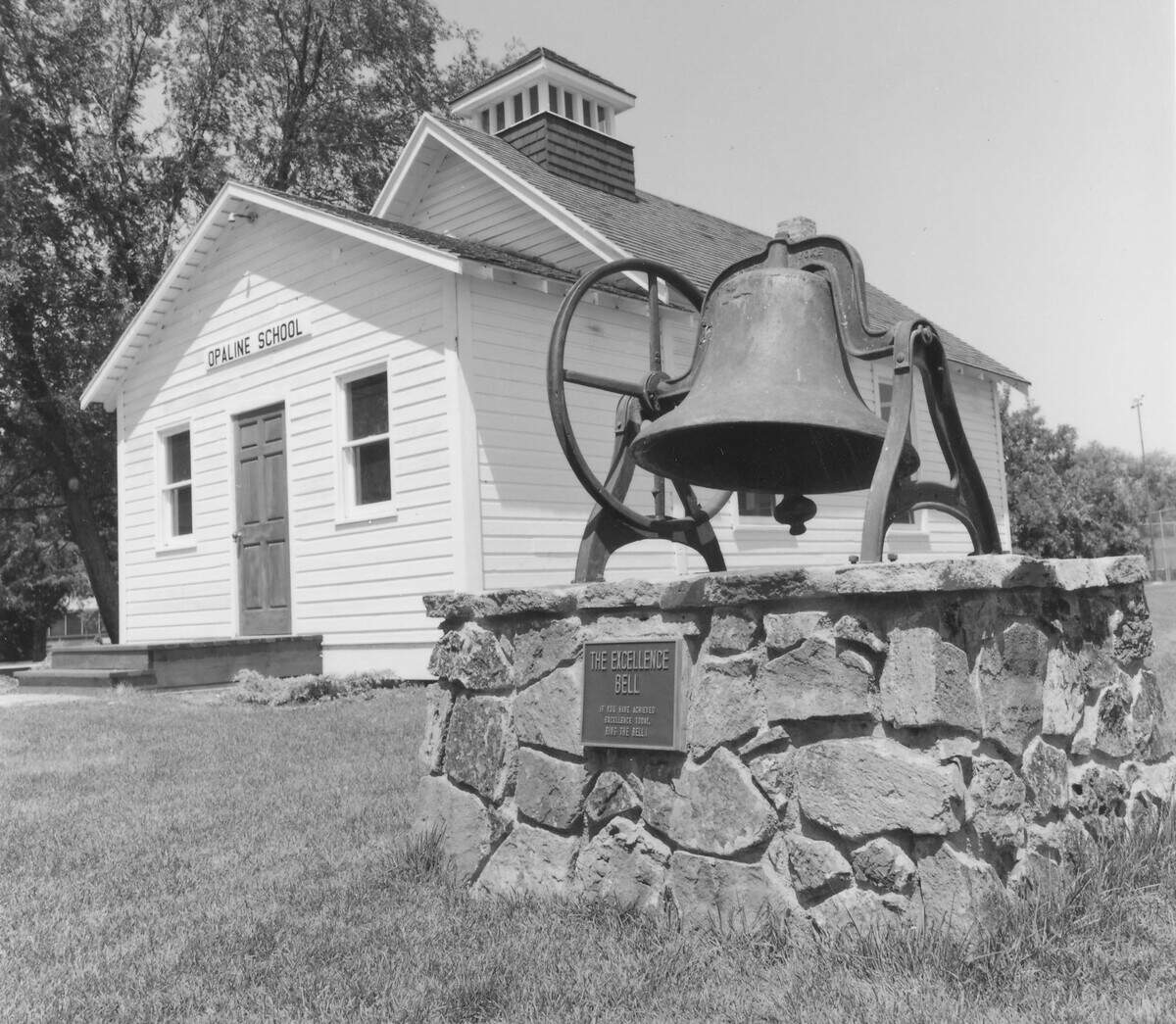 This undated photo shows the Opaline School and the Excellence Bell, which were moved to the Boise State campus from separate locations. The Opaline School was subsequently moved to its current location at Albertsons Stadium to make space for the Steve Appleton Tennis Center.