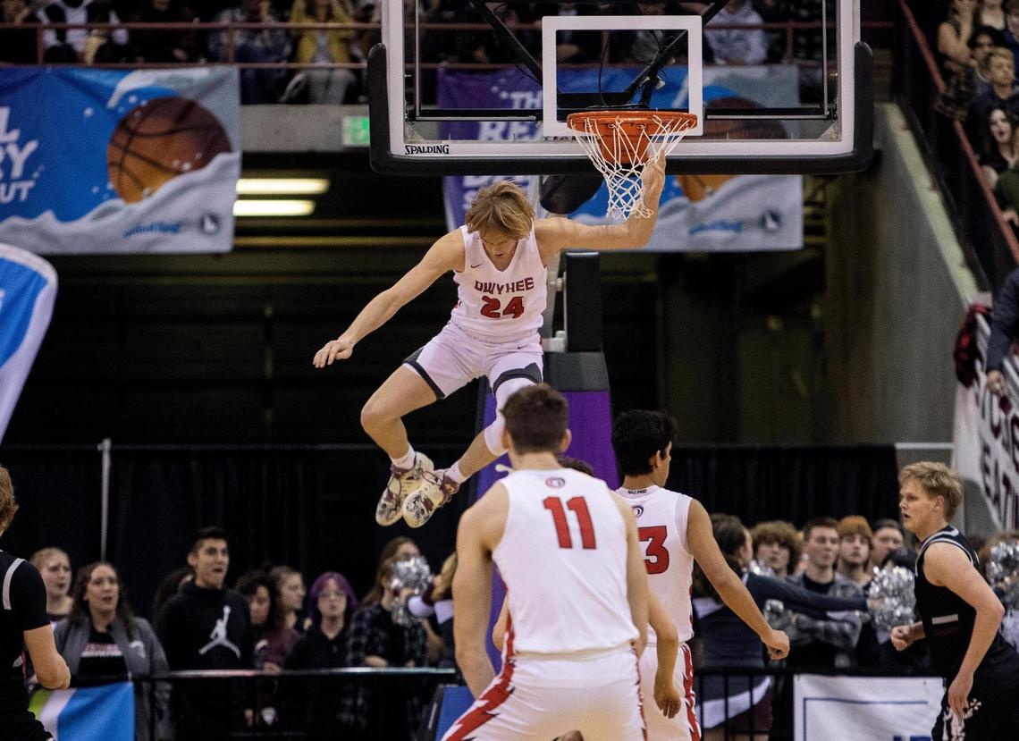 Owyhee senior Jack Payne swings from the rim after a first-quarter dunk in the 5A boys basketball state championship game Saturday.