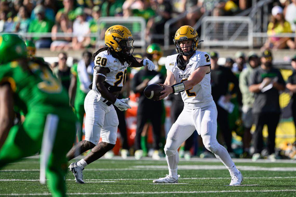 Idaho quarterback Jack Layne, right, hands the ball off to running back Elisha Cummings in their season opener against Oregon. The Vandals play an FCS quarterfinal against top-ranked Montana State on Friday.