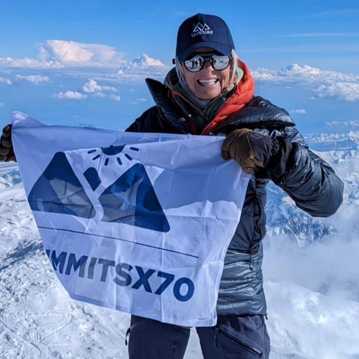 Eva Steinwald, of Meridian, holds a flag at the top of Denali, the tallest peak in North America. Steinwald summited Denali in July 2024 as part of her goal to climb the highest peak on each continent.
