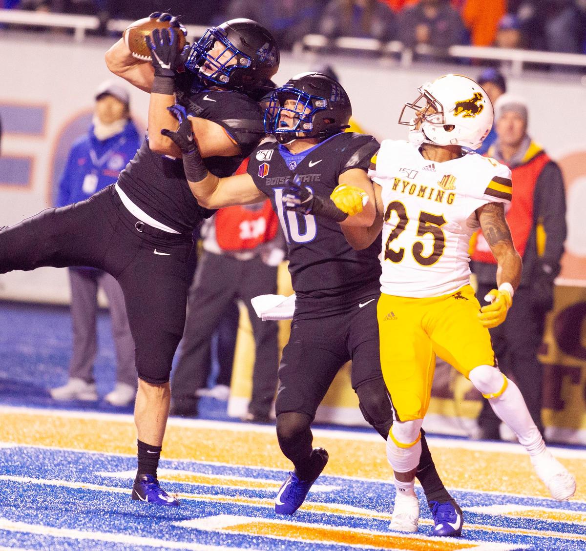 Boise State linebacker Riley Whimpey, left, and safety Kekoa Nawahine and Wyoming wide receiver Austin Conway fight for a pass in the end zone during overtime Saturday night at Albertsons Stadium. Whimpey nearly intercepted the throw.