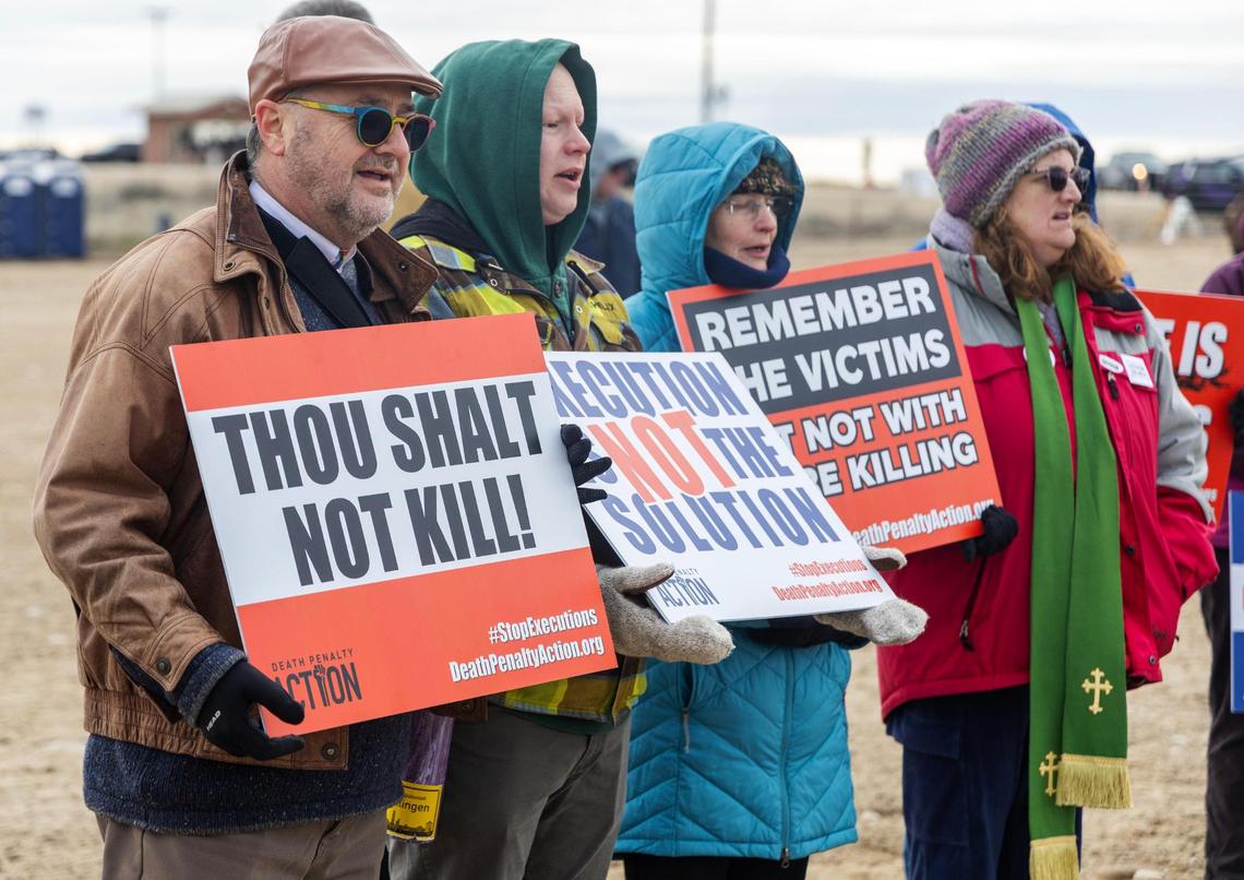 The Rev. Duane Anders of the Cathedral of the Rockies, left, and the Rev. Buddy Gharring of Hillview United Methodist Church, second from left, sing “Amazing Grace” with other protesters against the death penalty on Wednesday outside of the Idaho Maximum Security Institution in Kuna.