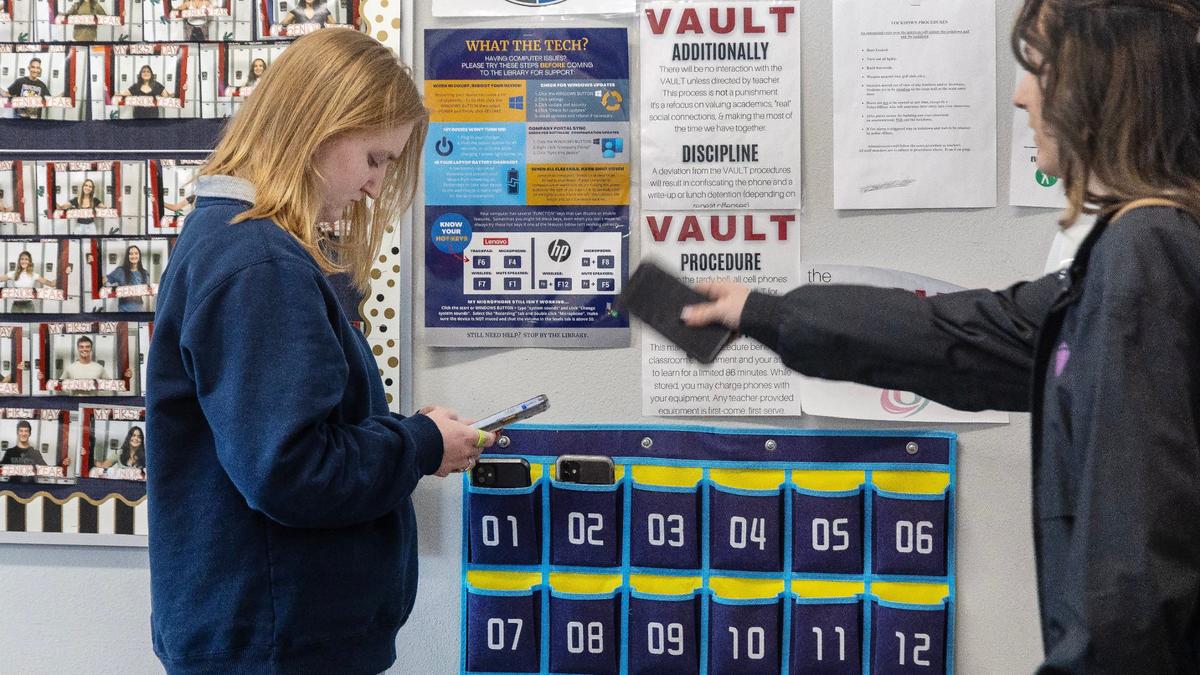 Owyhee High School junior Chloe Bowman, 17, checks her phone one last time before storing it in the VAULT at the start of class, Thursday, May 2, 2024. Owyhee High School uses a system called VAULT (Valuing Academics, Utilizing Learning Time) having students place their cell phones in a pocket holder during class instruction time and retrieving them when class ends.