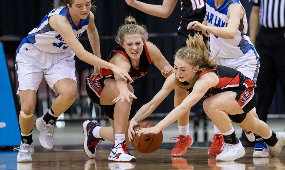 Melba guard Hallie Arnold, right, and teammate Keylee Wilson dive for a loose ball with Bear Lake’s Kalisha Parker on Saturday at the Ford Idaho Center.